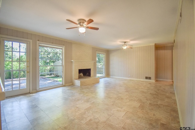 unfurnished living room with crown molding, ceiling fan, and a fireplace