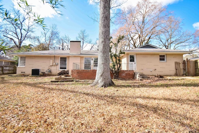 rear view of property with cooling unit and a lawn