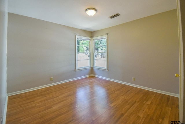 unfurnished room with hardwood / wood-style floors