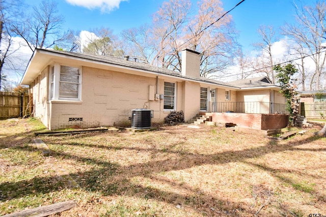 rear view of property featuring cooling unit and a lawn