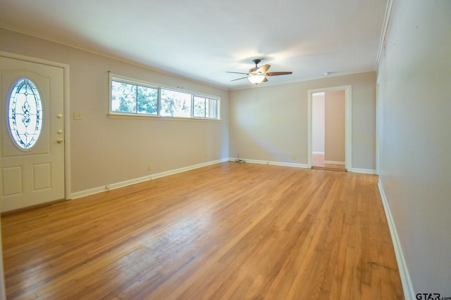 foyer entrance with crown molding, ceiling fan, and light wood-type flooring