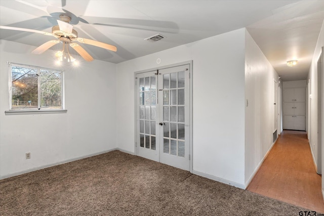 empty room with french doors, ceiling fan, and carpet floors