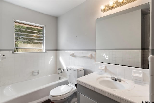 bathroom with a tub, vanity, toilet, and tile walls