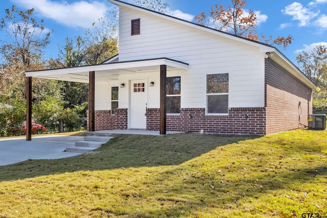 view of front facade with central air condition unit, a front lawn, and a carport