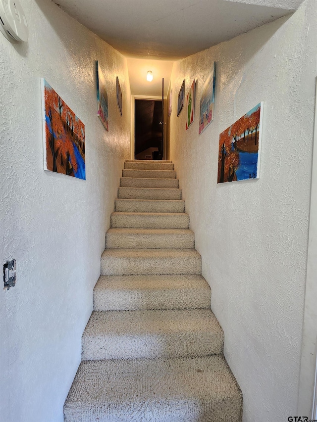 stairs with a wall unit AC and a textured wall