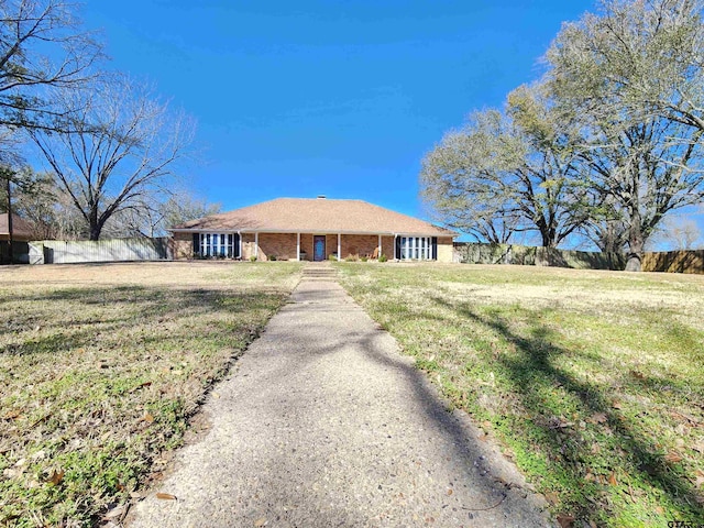 ranch-style house with a front yard, fence, and brick siding