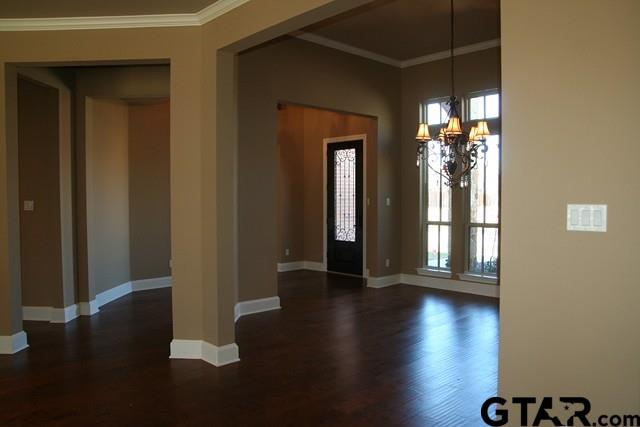 2308 Pinehurst St, Tyler, TX 75703 - entrance foyer with a chandelier, dark wood-type flooring, baseboards, crown molding, and healthy amount of natural light