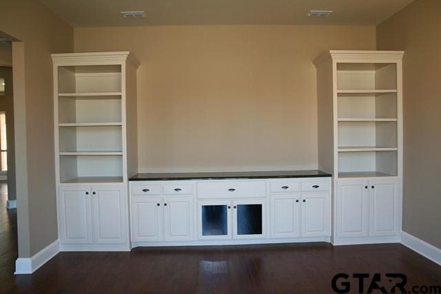 2308 Pinehurst St, Tyler, TX 75703 - unfurnished living room with baseboards and dark wood-style floors