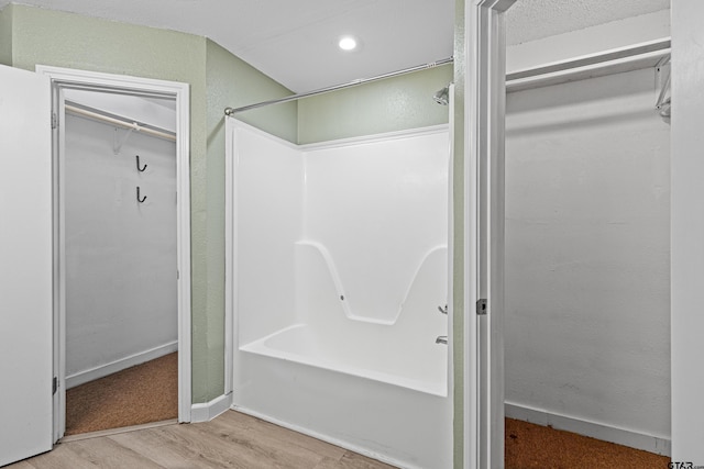 bathroom featuring wood-type flooring and shower / tub combination