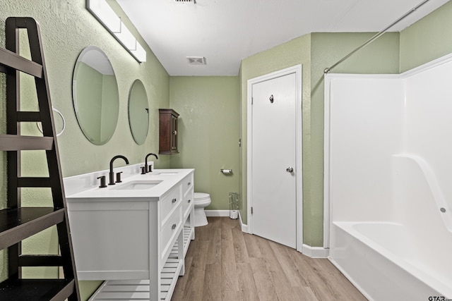 bathroom featuring vanity, wood-type flooring, and toilet