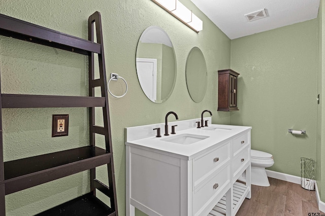 bathroom with hardwood / wood-style floors, vanity, and toilet