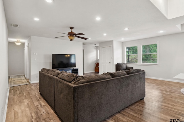 living area with baseboards, recessed lighting, and light wood-style floors