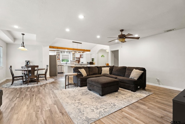 living area with visible vents, arched walkways, baseboards, light wood-style floors, and recessed lighting