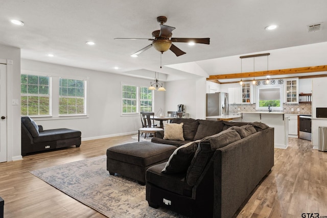 living area featuring recessed lighting, visible vents, ceiling fan with notable chandelier, and light wood-type flooring