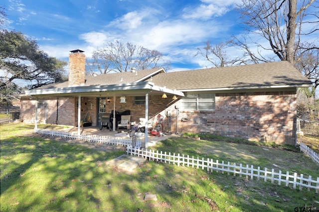 back of property with a yard and a patio area