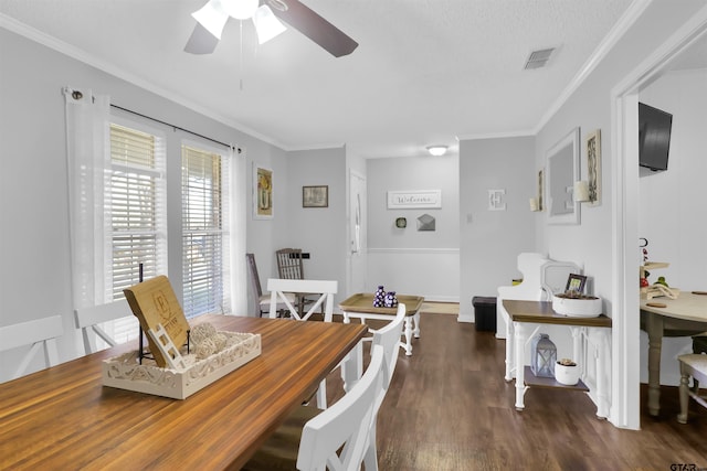 dining space featuring dark hardwood / wood-style flooring, a textured ceiling, ceiling fan, and ornamental molding