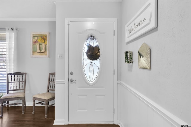 foyer entrance with dark wood-type flooring, crown molding, and a wealth of natural light