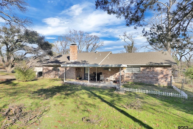 rear view of property featuring a yard and a patio area