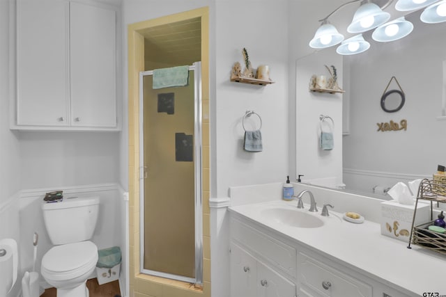 bathroom featuring vanity, a shower with shower door, and toilet