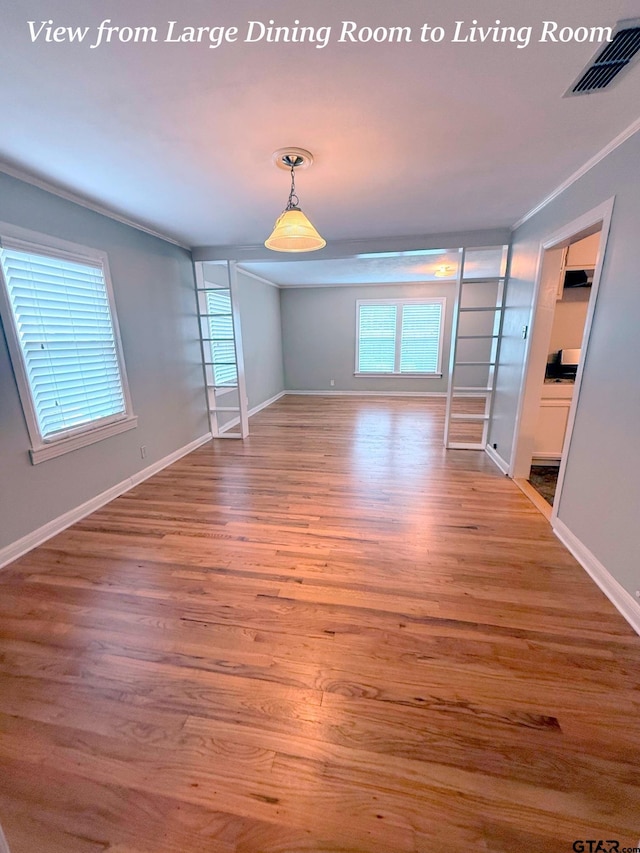 902 W 9th St, Tyler, TX 75701 - empty room featuring healthy amount of natural light, crown molding, wood finished floors, and baseboards