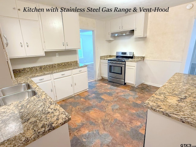 902 W 9th St, Tyler, TX 75701 - kitchen with stainless steel gas stove, under cabinet range hood, stone finish floors, white cabinets, and a sink