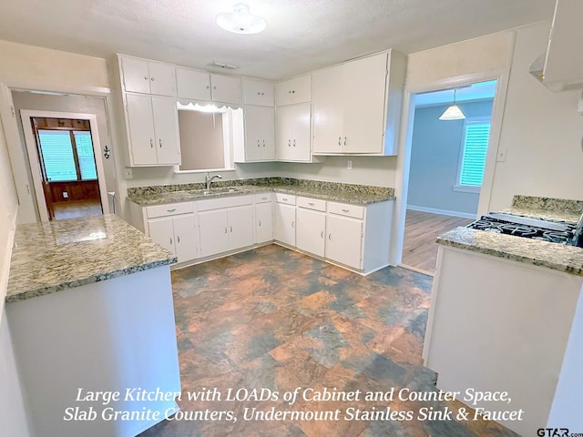 902 W 9th St, Tyler, TX 75701 - kitchen with healthy amount of natural light, white cabinetry, and light stone counters