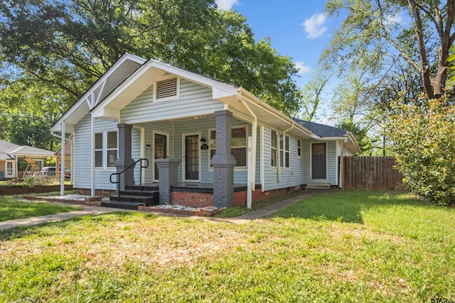bungalow-style house with fence, a porch, and a front yard