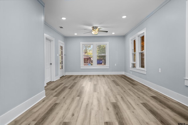 spare room featuring visible vents, baseboards, a ceiling fan, wood finished floors, and crown molding