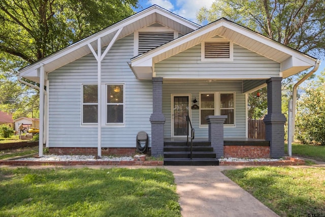 bungalow-style house featuring a front lawn and covered porch