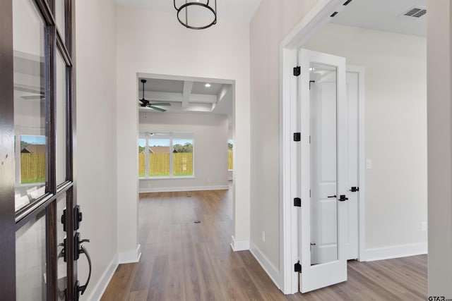 corridor featuring beamed ceiling, light hardwood / wood-style flooring, and coffered ceiling