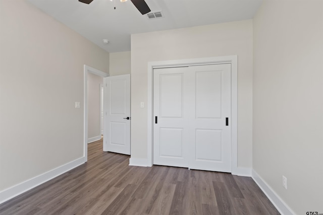 unfurnished bedroom featuring ceiling fan, wood-type flooring, and a closet