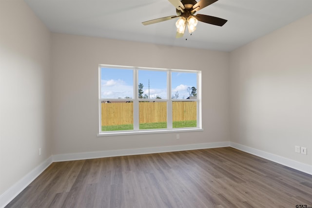 empty room with hardwood / wood-style flooring, plenty of natural light, and ceiling fan