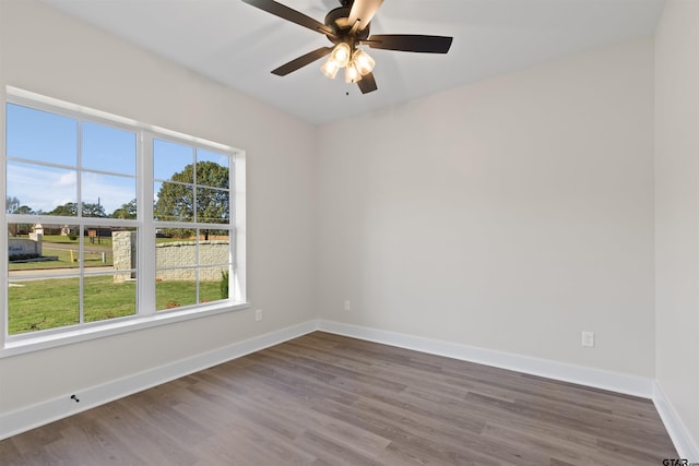 spare room with dark hardwood / wood-style floors and ceiling fan