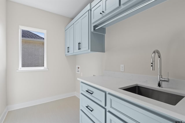 kitchen featuring light stone countertops and sink