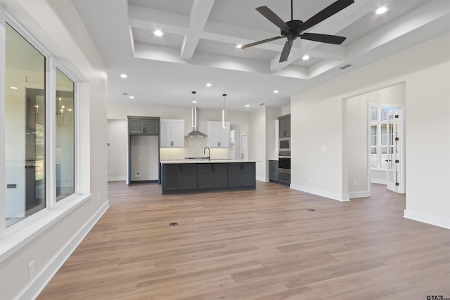 unfurnished living room with beam ceiling, light hardwood / wood-style floors, plenty of natural light, and coffered ceiling