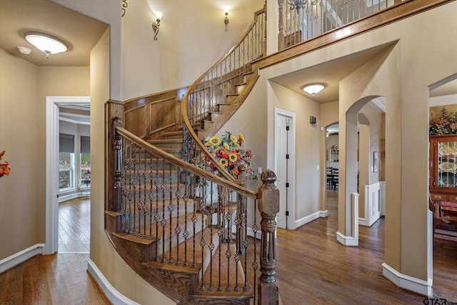 1299 Shadow Lks, Terrell, TX 75160 - staircase featuring arched walkways, wood finished floors, and a towering ceiling