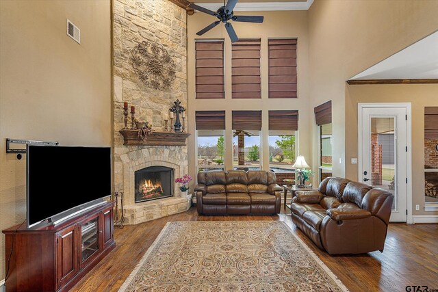 1299 Shadow Lks, Terrell, TX 75160 - living room with a high ceiling, a stone fireplace, wood-type flooring, a ceiling fan, and crown molding
