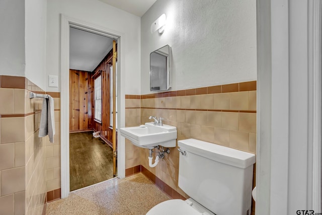 bathroom with sink, hardwood / wood-style flooring, toilet, and tile walls