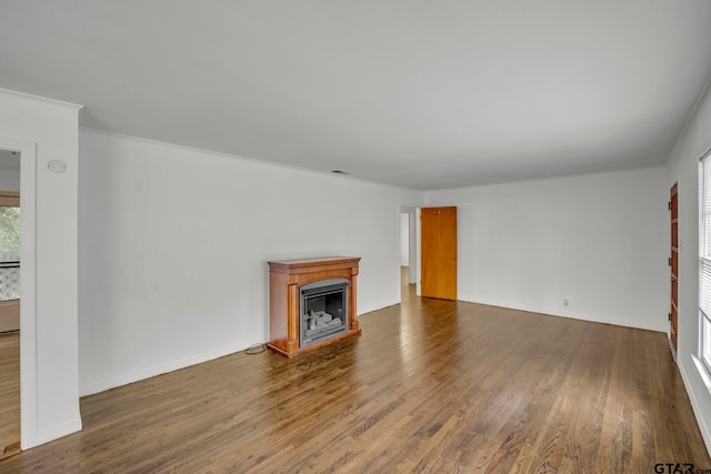 unfurnished living room with ornamental molding and hardwood / wood-style flooring