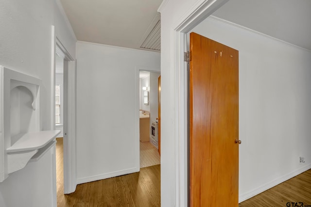 hallway with hardwood / wood-style flooring and crown molding