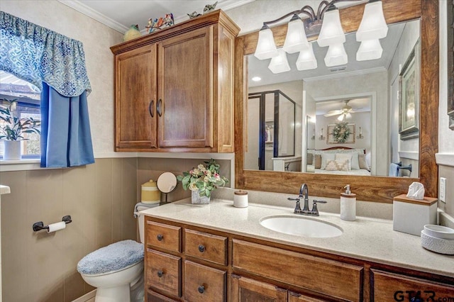 bathroom featuring ceiling fan, ornamental molding, vanity, and toilet