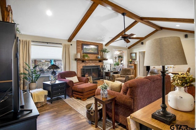 living room with a fireplace, dark wood-type flooring, ceiling fan, and lofted ceiling with beams