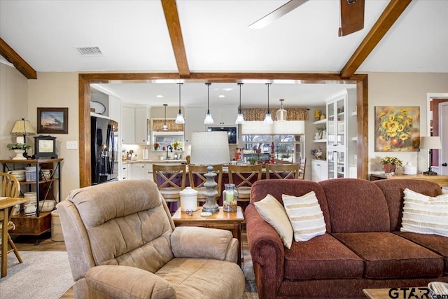 living room featuring sink and beamed ceiling