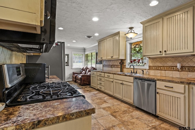 306 Dellwood Dr, Mount Pleasant, TX 75455 - kitchen featuring stainless steel appliances, cream cabinetry, ornamental molding, backsplash, and recessed lighting