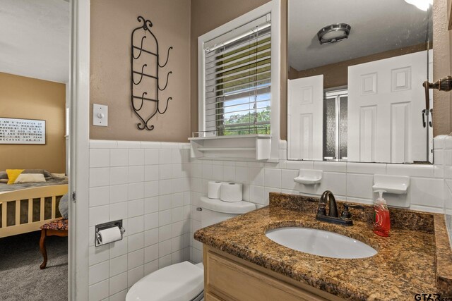 306 Dellwood Dr, Mount Pleasant, TX 75455 - bathroom featuring vanity, tile walls, and a wainscoted wall