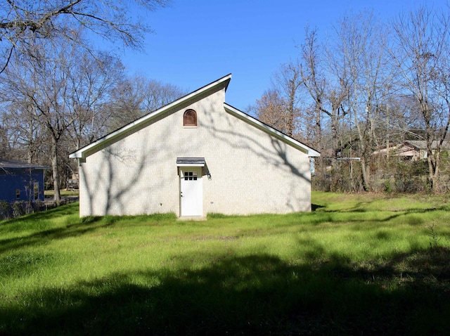 exterior space featuring brick siding and a yard