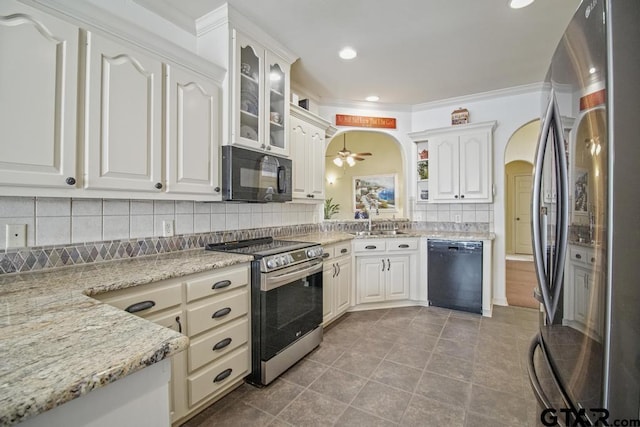 502 Northcreek Dr, Chandler, TX 75758 - kitchen with black appliances, arched walkways, a sink, ceiling fan, and decorative backsplash