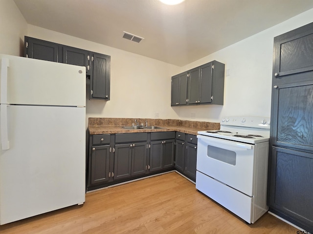 201 W Paschal St, Troup, TX 75789 - kitchen featuring white appliances, dark countertops, a sink, and light wood-style flooring