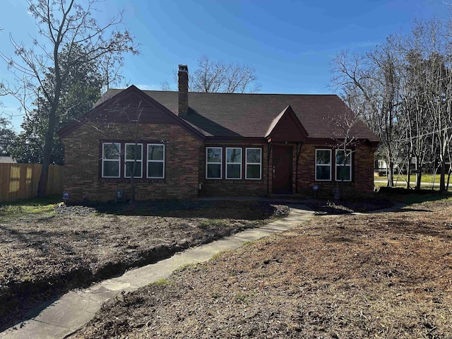 view of front of house featuring a chimney and fence