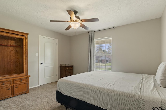 carpeted bedroom with a textured ceiling and ceiling fan